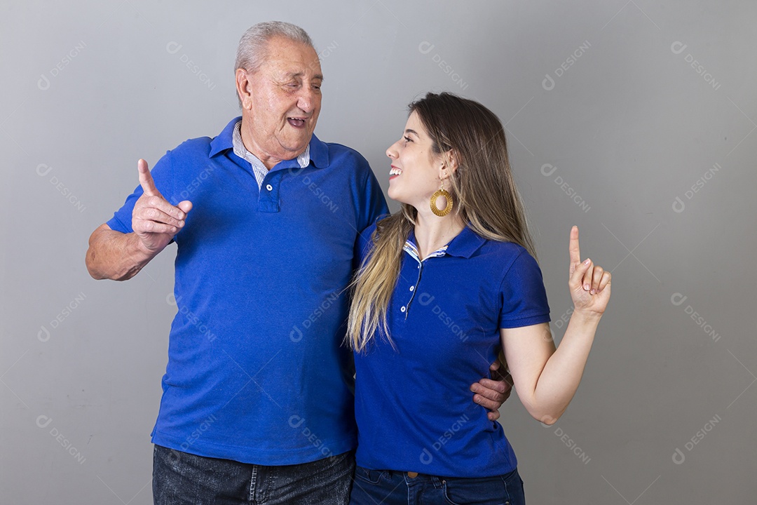 Homem idoso e jovem mulher combinando de camiseta azul