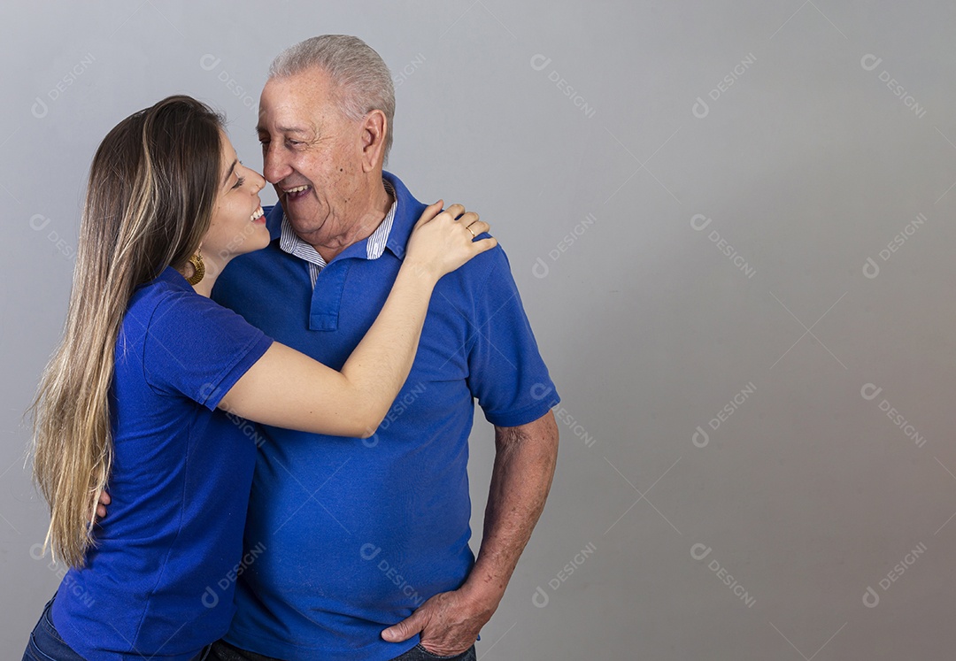 Homem idoso e jovem mulher combinando de camiseta azul