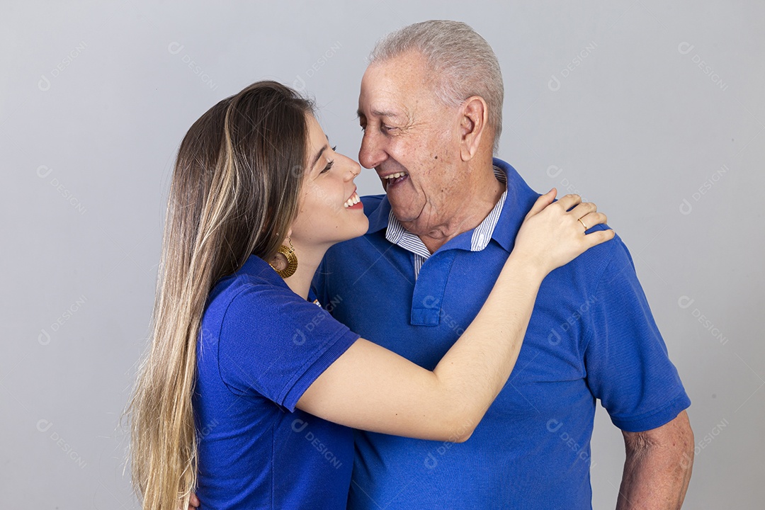 Homem idoso e jovem mulher combinando de camiseta azul