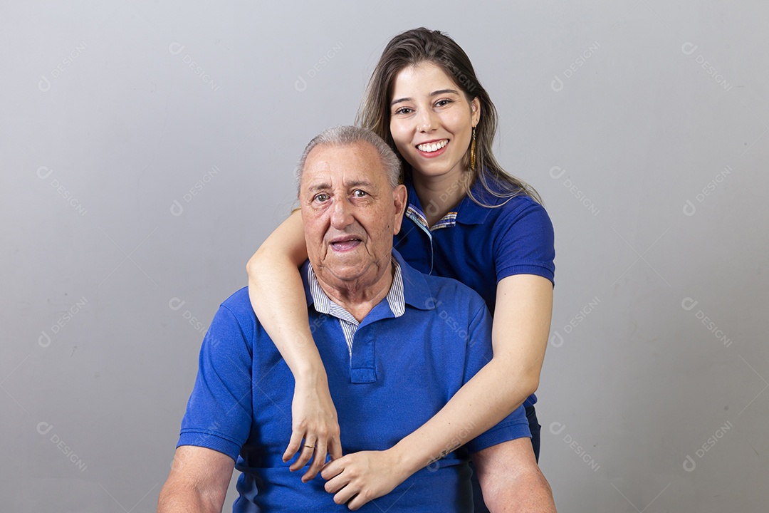 Homem idoso e jovem mulher combinando de camiseta azul