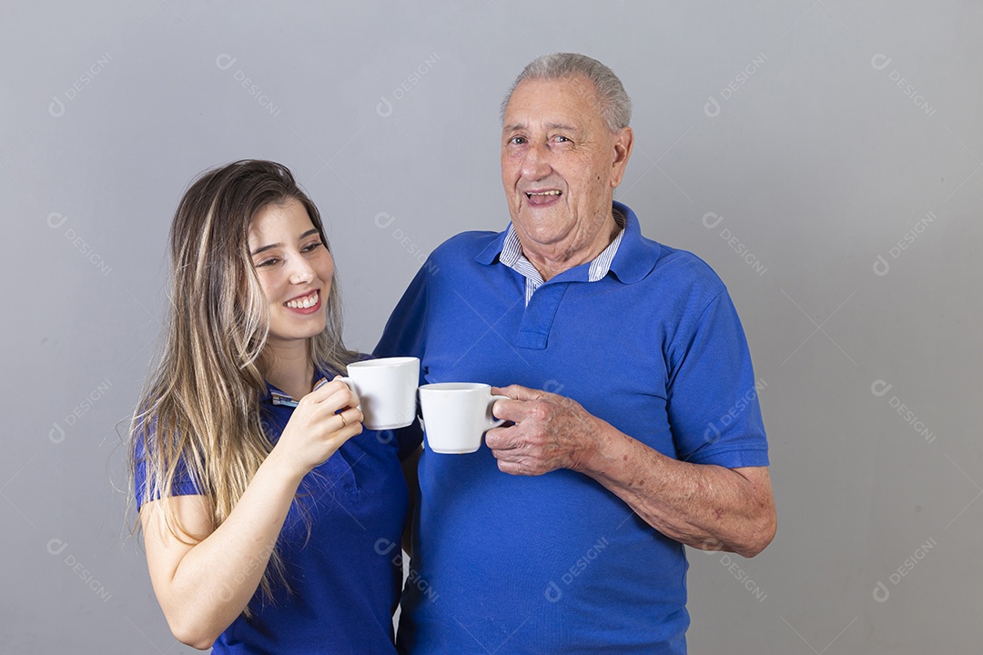 Homem idoso e jovem mulher combinando de camiseta azul