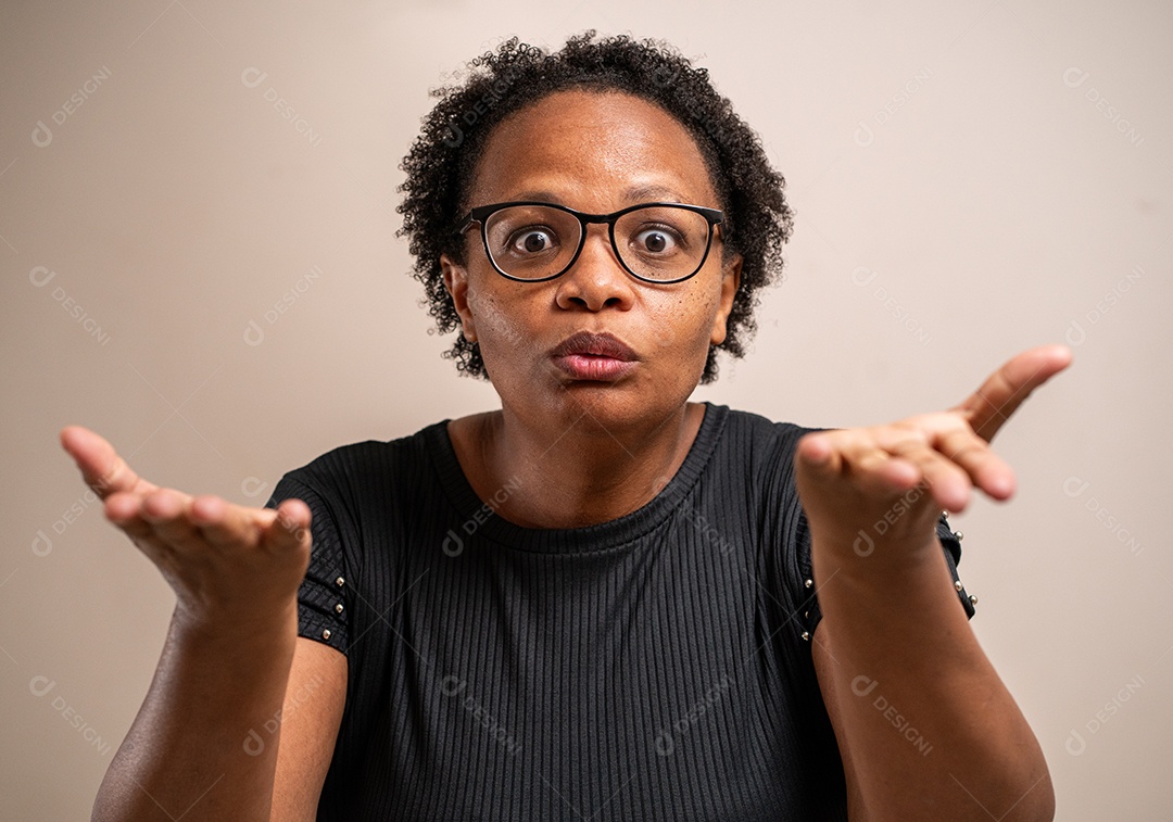 Mulher negra com as mãos estendidas voltadas para cima e expressão de dúvida sobre fundo pastel.