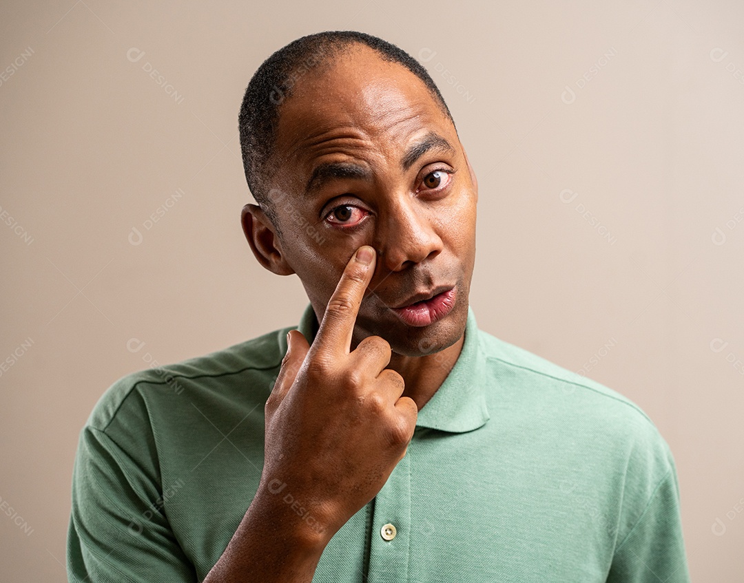 Homem apontando para o olho em um fundo pastel.