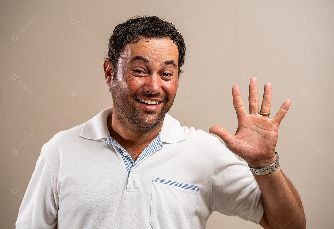 Homem com barba por fazer sorrindo e acenando em fundo pastel.