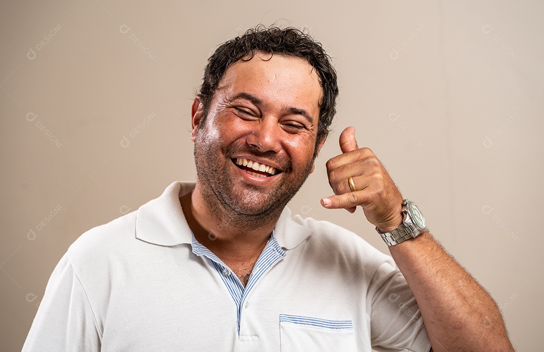 Homem sorrindo e fazendo pendurado solto em fundo pastel.