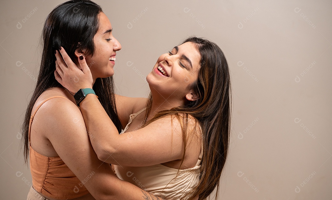 Mulheres jovens olhando umas para as outras apaixonadas em fundo pastel.