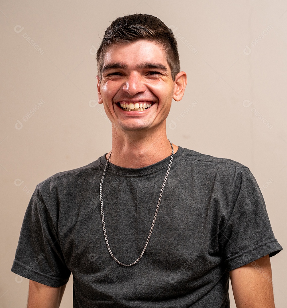 Jovem sorrindo com os braços cruzados em fundo pastel.