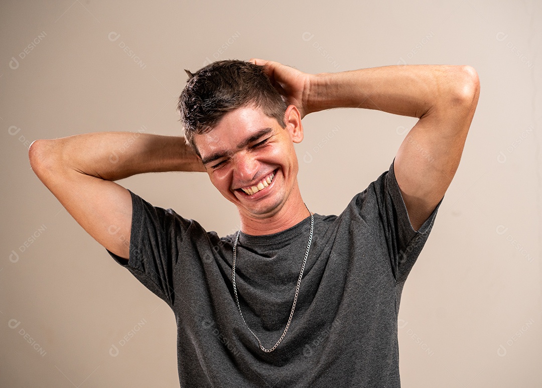 Jovem sorrindo com os braços cruzados em fundo pastel.