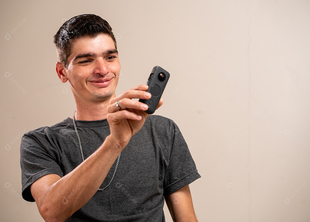 Jovem sorrindo com os braços cruzados em fundo pastel.