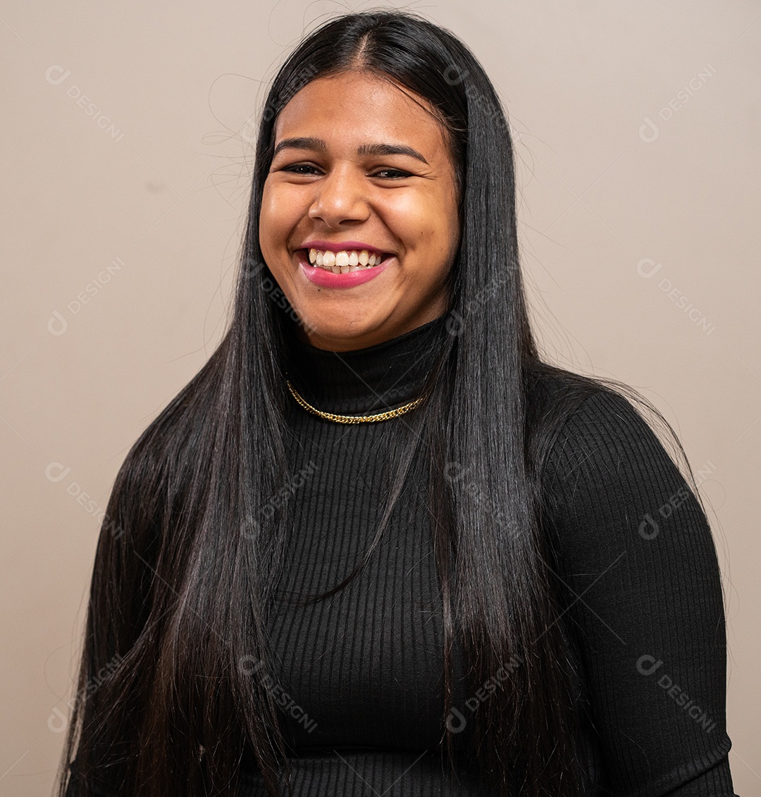 Jovem morena com cabelos longos sorrindo em fundo pastel.