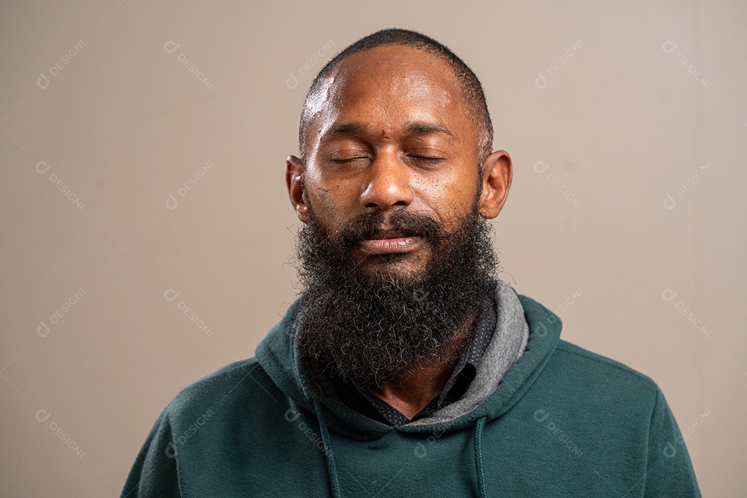 Homem negro barbudo sorrindo em fundo pastel.