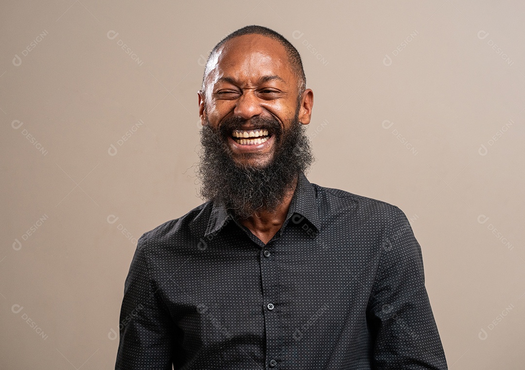 Homem negro barbudo sorrindo em fundo pastel.
