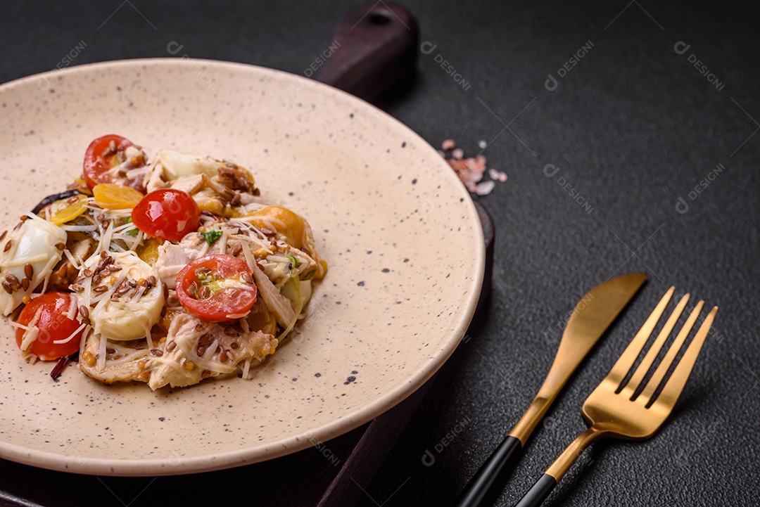 Deliciosa salada fresca com frango, ovos de codorna, tomate cereja, alface, sal e especiarias sobre fundo escuro de concreto