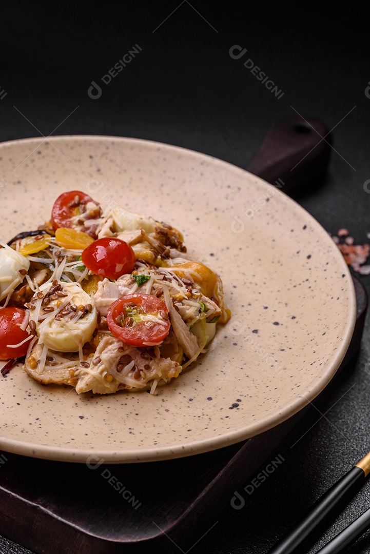 Deliciosa salada fresca com frango, ovos de codorna, tomate cereja, alface, sal e especiarias sobre fundo escuro de concreto