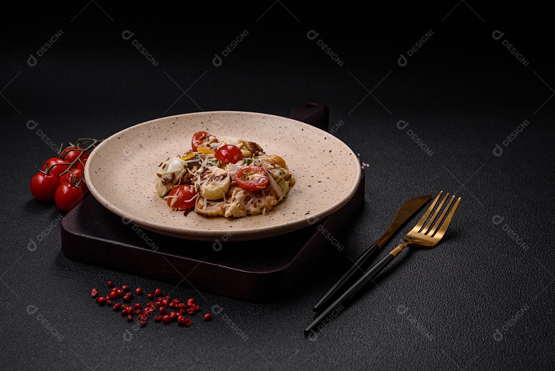 Deliciosa salada fresca com frango, ovos de codorna, tomate cereja, alface, sal e especiarias sobre fundo escuro de concreto