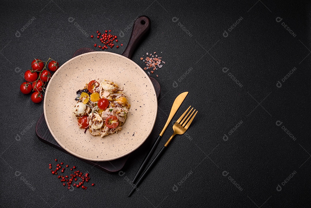 Deliciosa salada fresca com frango, ovos de codorna, tomate cereja, alface, sal e especiarias sobre fundo escuro de concreto