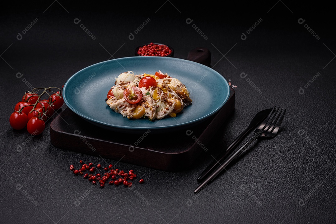 Deliciosa salada fresca com frango, ovos de codorna, tomate cereja, alface, sal e especiarias sobre fundo escuro de concreto