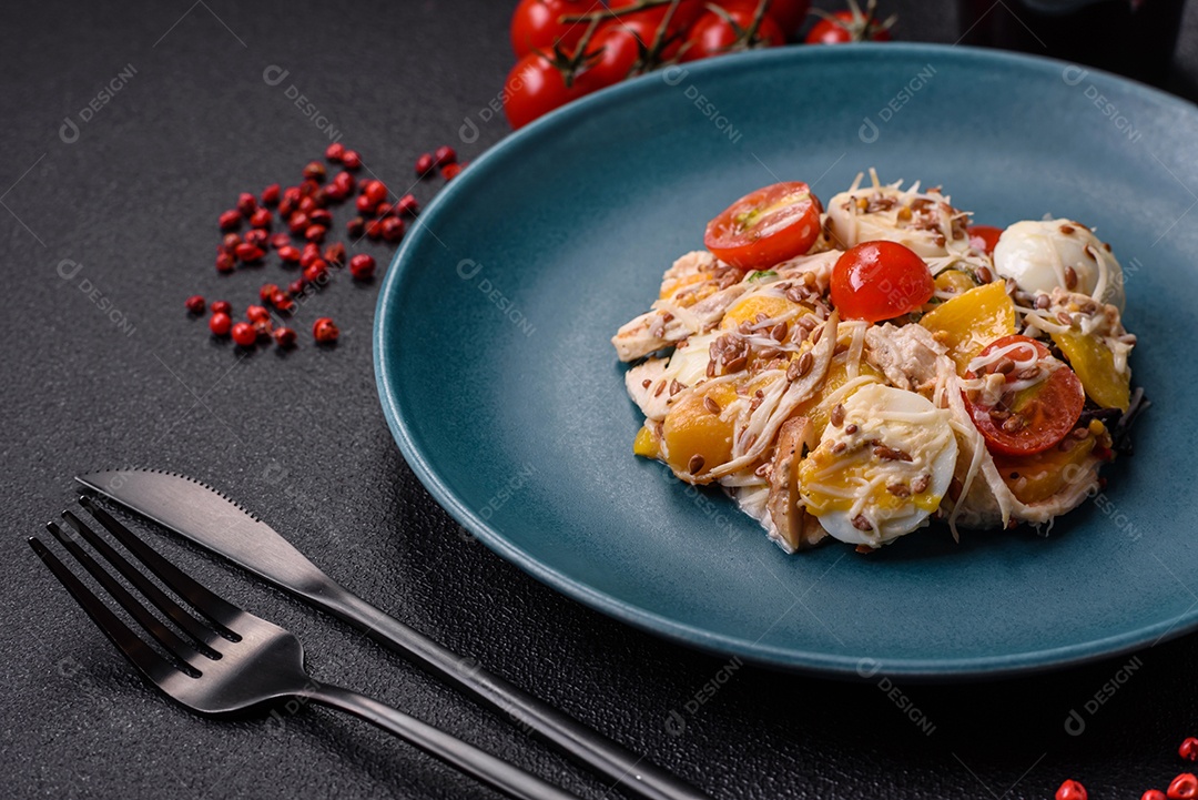 Deliciosa salada fresca com frango, ovos de codorna, tomate cereja, alface, sal e especiarias sobre fundo escuro de concreto