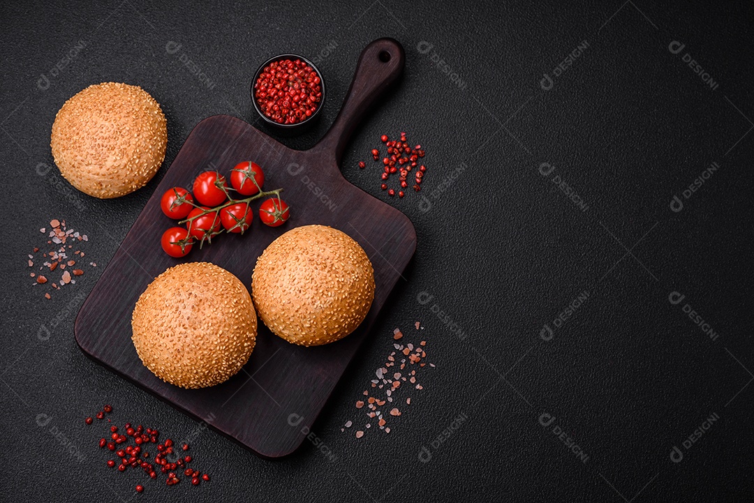 Delicioso pão redondo branco crocante fresco com sementes e grãos sobre um fundo escuro de concreto