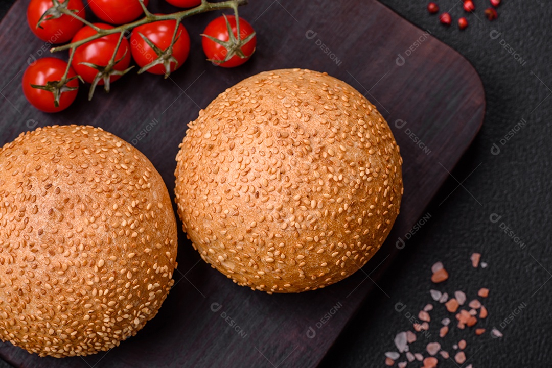Delicioso pão redondo branco crocante fresco com sementes e grãos sobre um fundo escuro de concreto