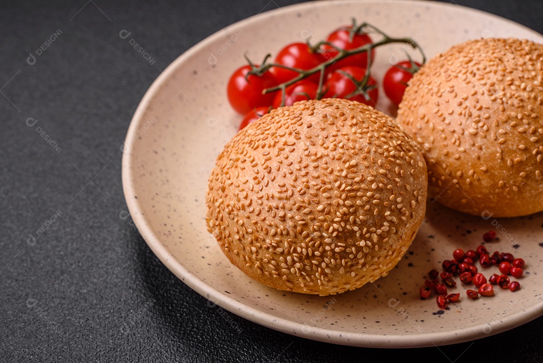 Delicioso pão redondo branco crocante fresco com sementes e grãos sobre um fundo escuro de concreto