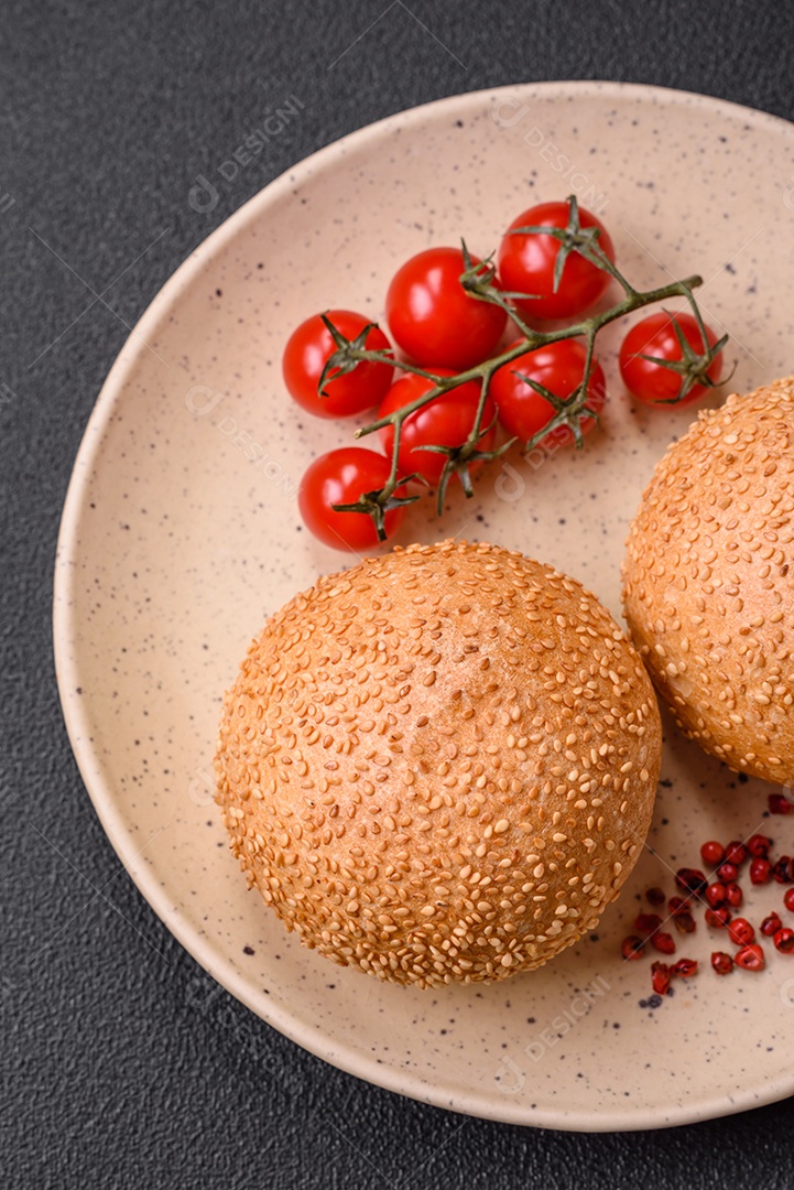 Delicioso pão redondo branco crocante fresco com sementes e grãos sobre um fundo escuro de concreto