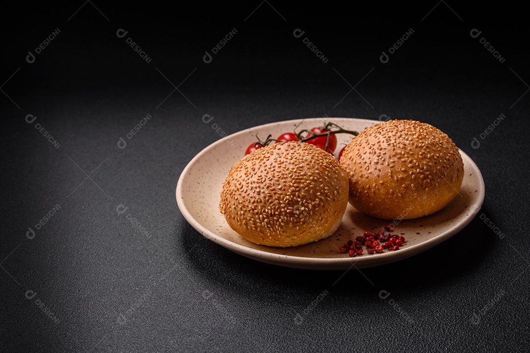 Delicioso pão redondo branco crocante fresco com sementes e grãos sobre um fundo escuro de concreto