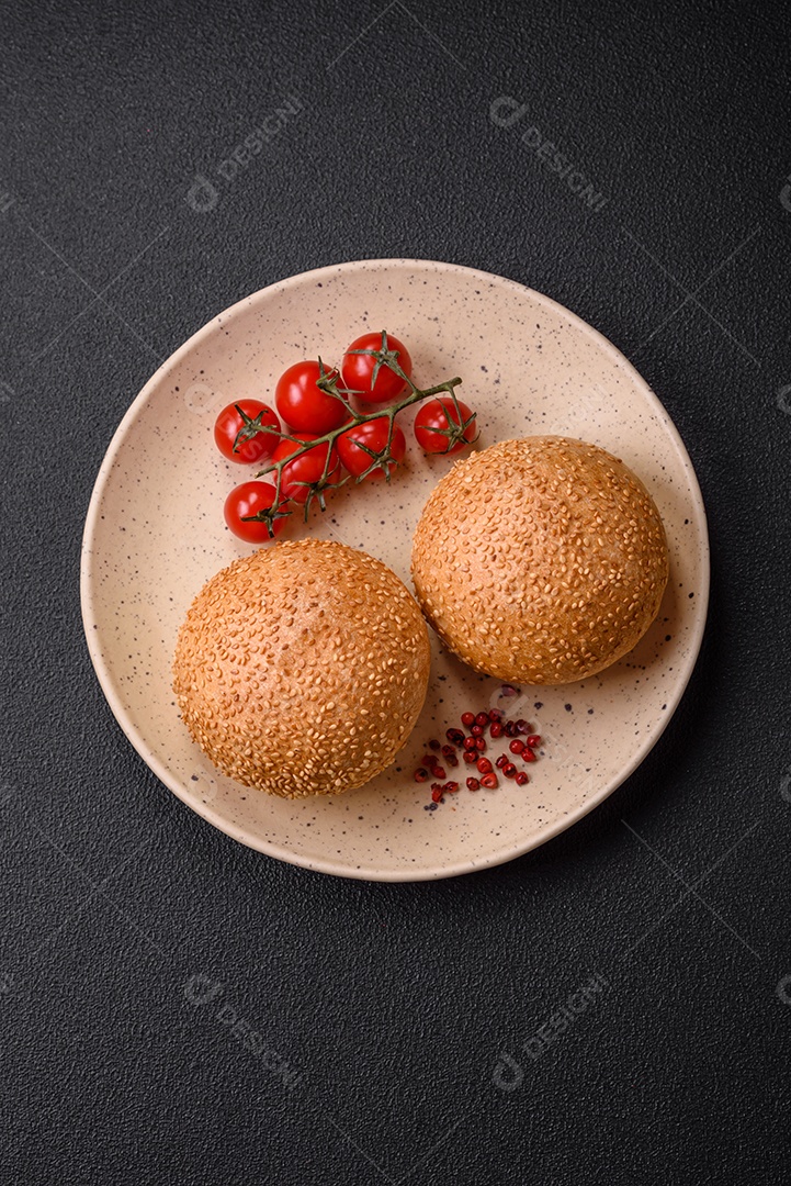 Delicioso pão redondo branco crocante fresco com sementes e grãos sobre um fundo escuro de concreto