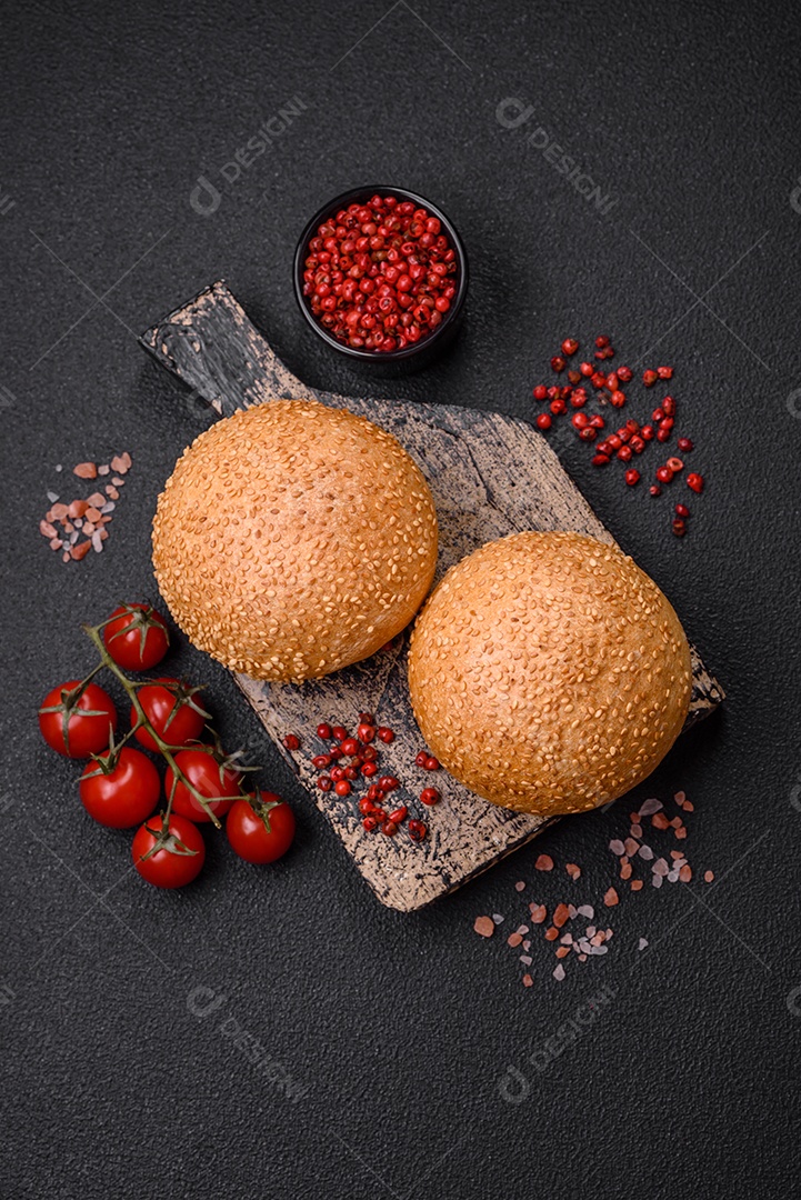 Delicioso pão redondo branco crocante fresco com sementes e grãos sobre um fundo escuro de concreto