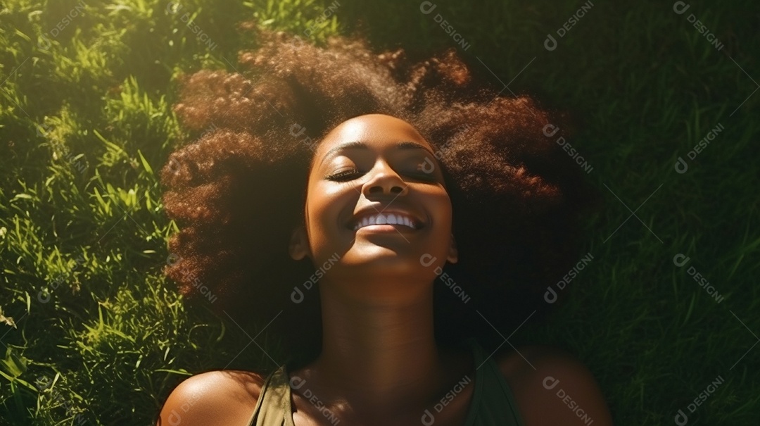 Sorridente jovem negra deitada na grama