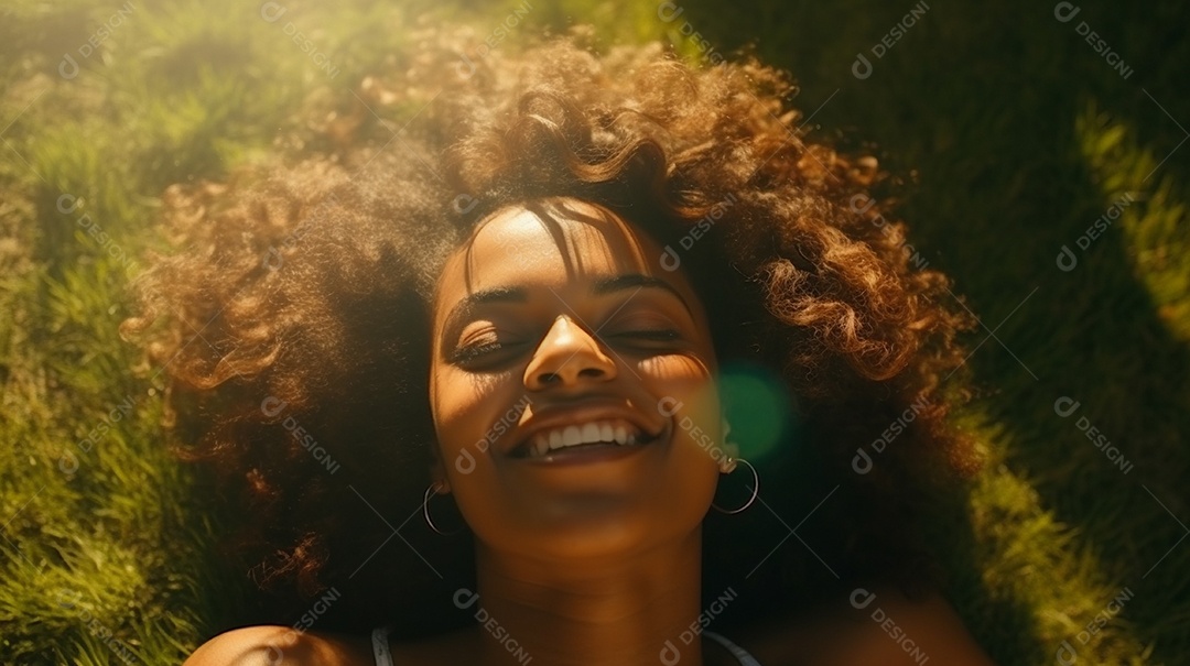 Sorridente jovem negra deitada na grama