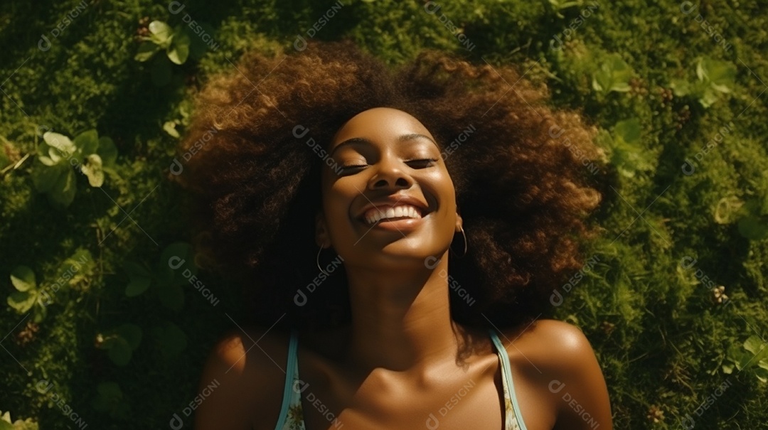 Sorridente jovem negra deitada na grama