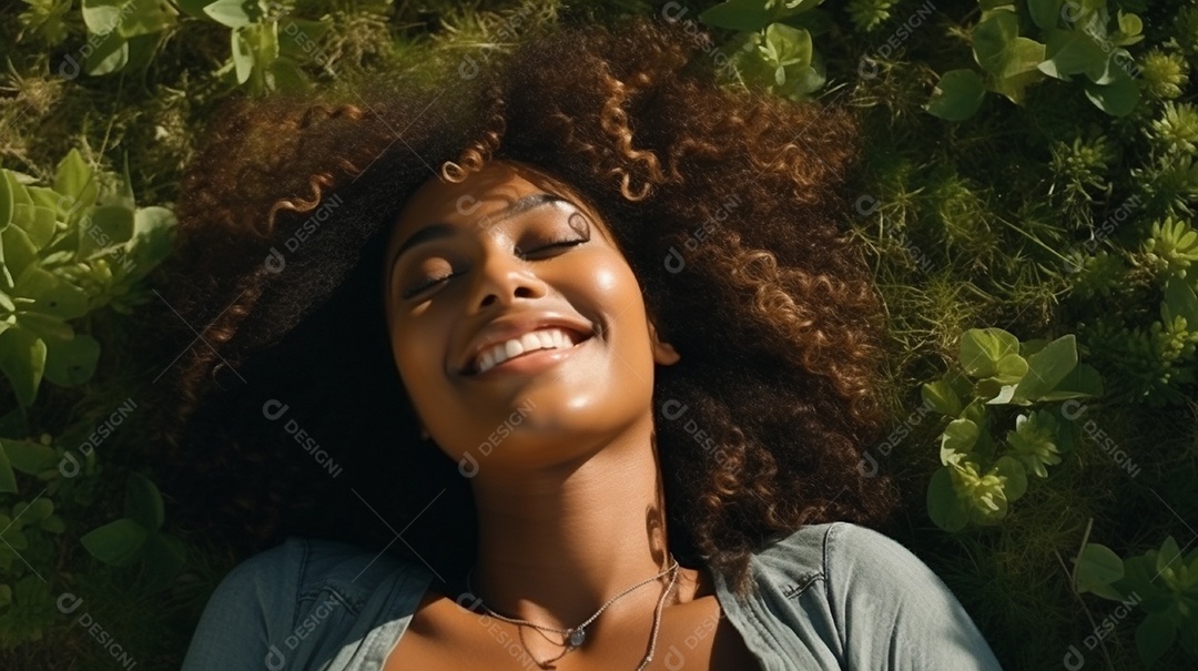 Sorridente jovem negra deitada na grama