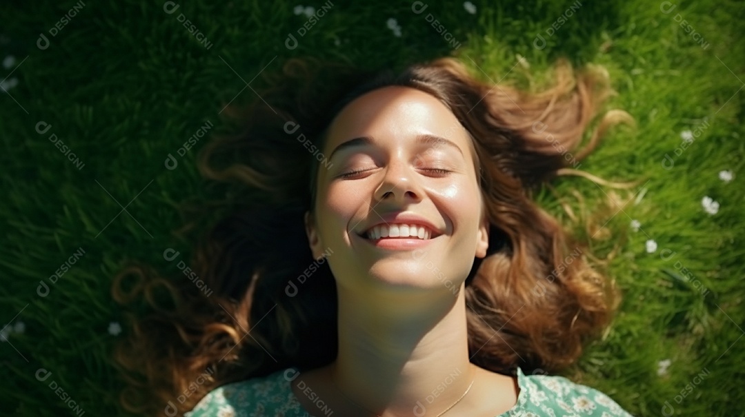 Mulher jovem sorridente, deitada na grama
