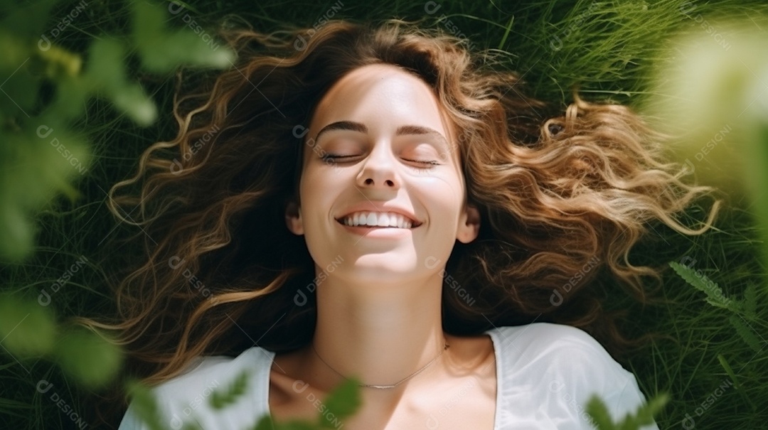 Mulher jovem sorridente, deitada na grama