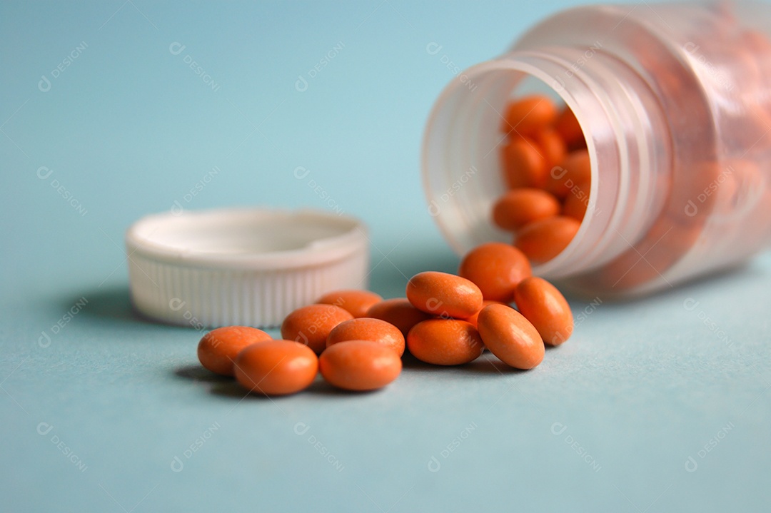 Frasco de cápsulas de remédios sobre fundo azul