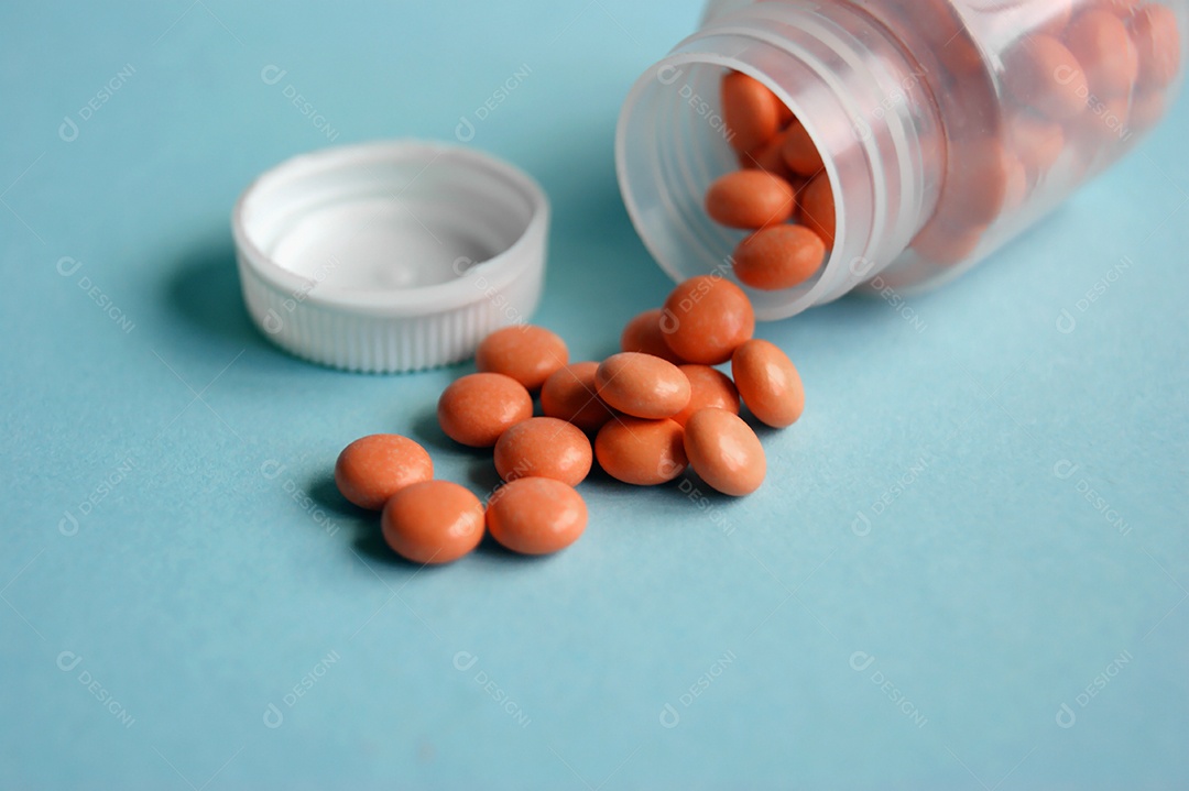 Frasco de remédios caído sobre fundo azul