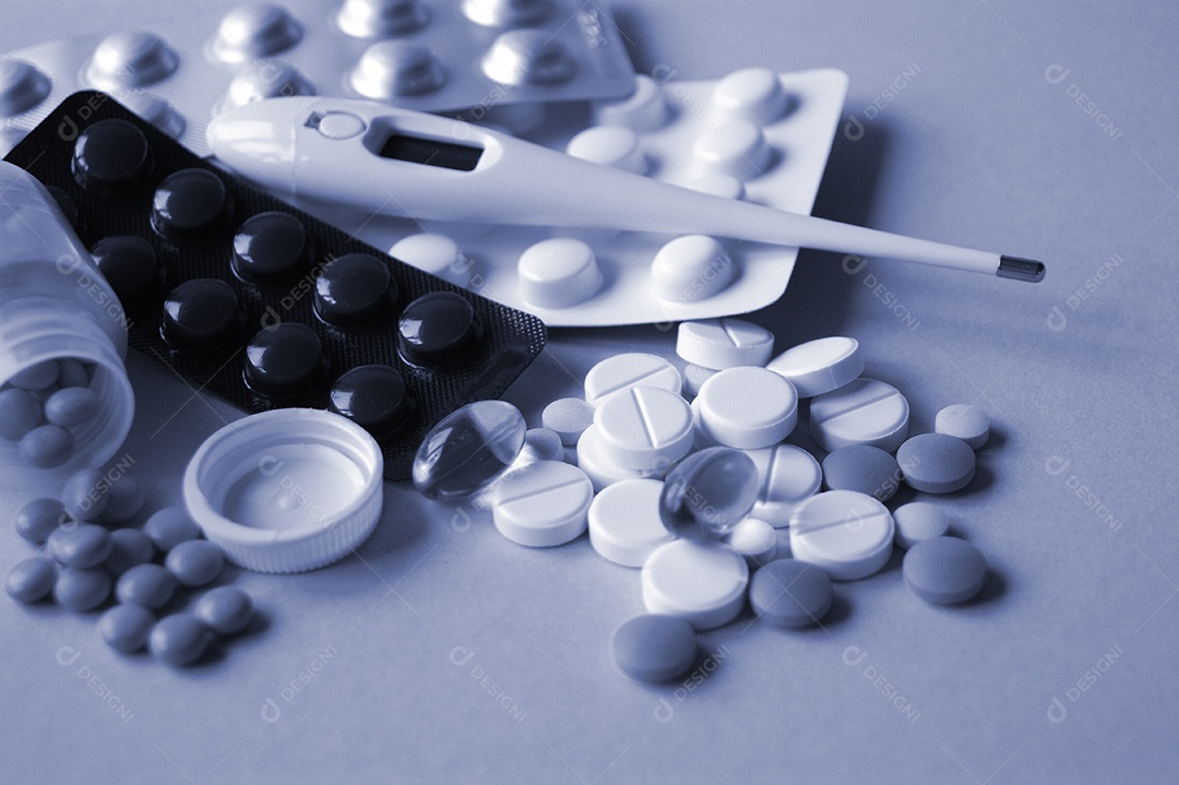 Diversos remédios em comprimidos e capsulas e um termômetro