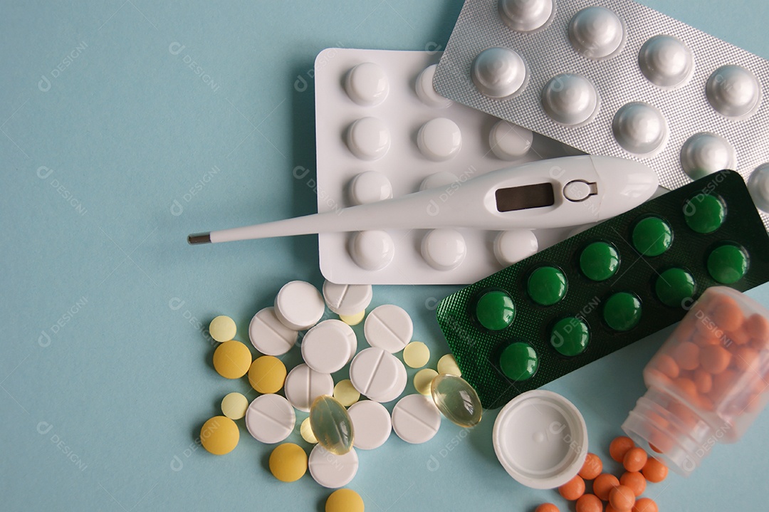 Cartelas de remédios e capsulas com termômetro em fundo azul