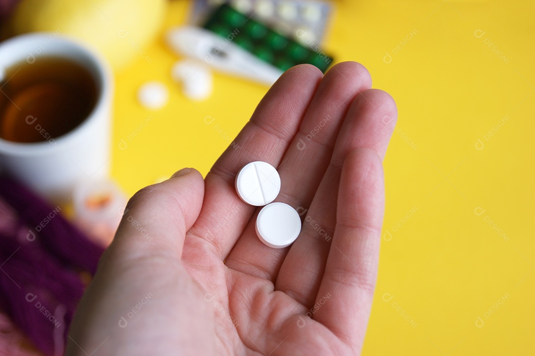 Um homem tem na mão uma porção de comprimidos para tratamento.