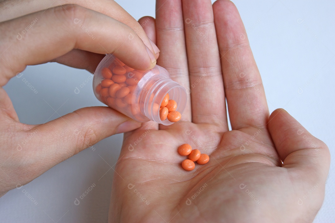 Um homem tem na mão uma porção de comprimidos para tratamento.