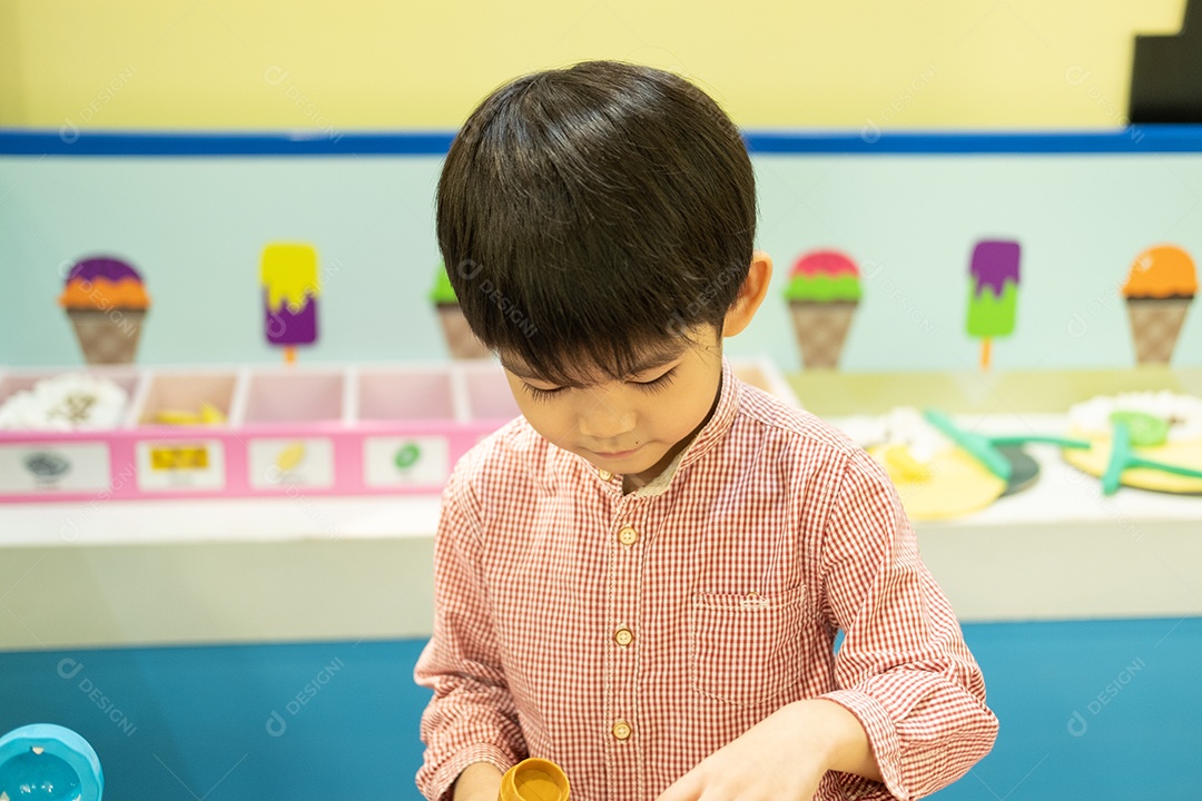 Menino asiático brincando de chef cozinhando comida