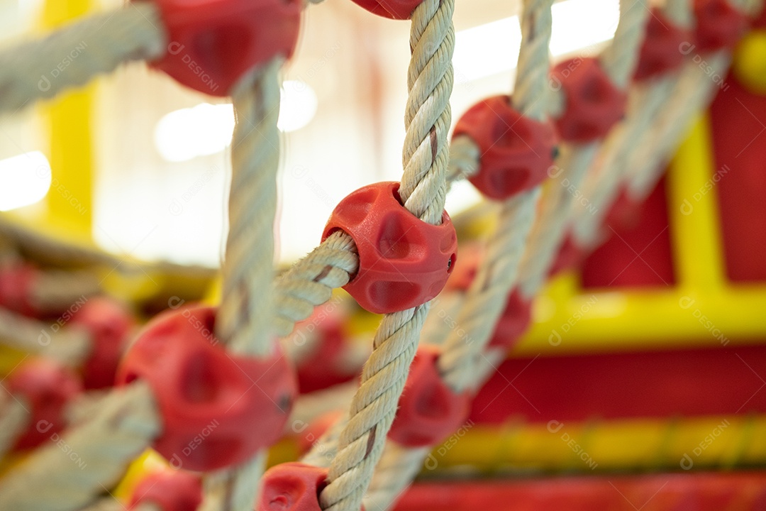 Rede de escalada em um parque infantil com pequenas bolas no chão