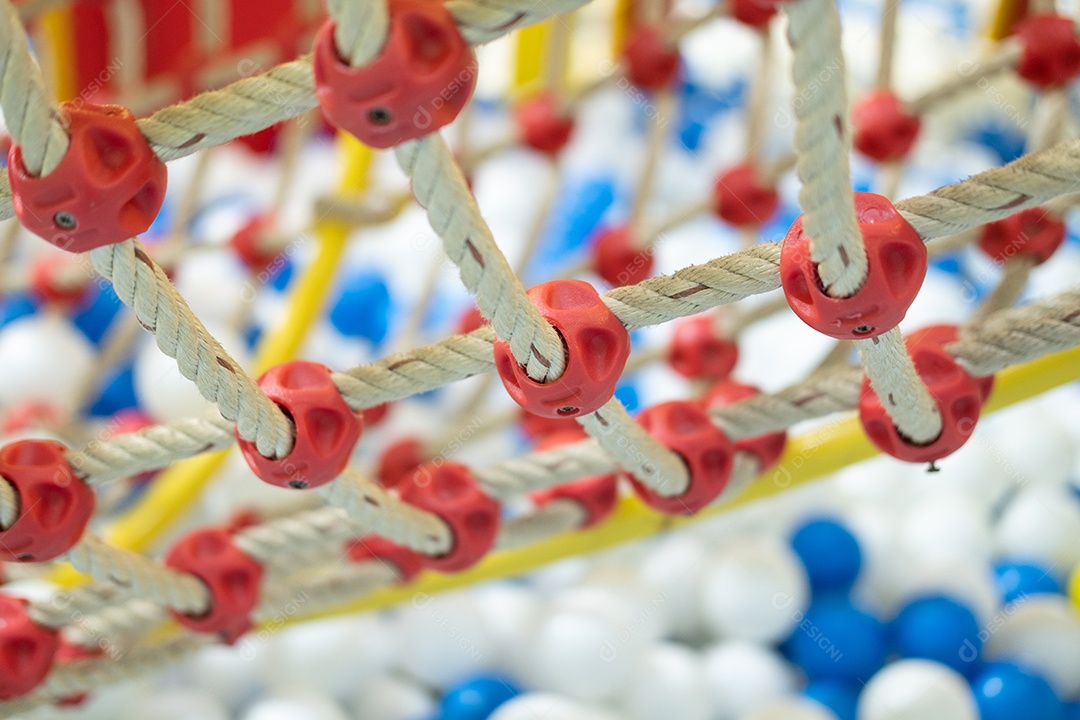 Rede de escalada em um parque infantil com pequenas bolas no chão