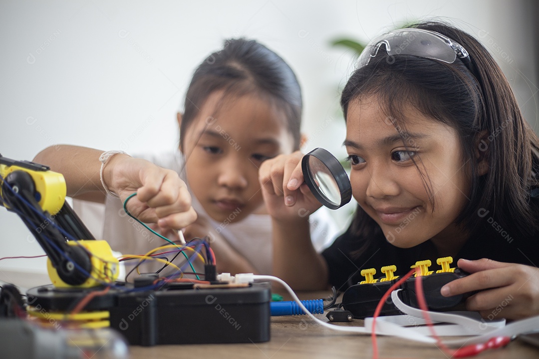 Crianças criativas aprendem em casa codificando carros-robôs e cabos de placas eletrônicas em STEM.