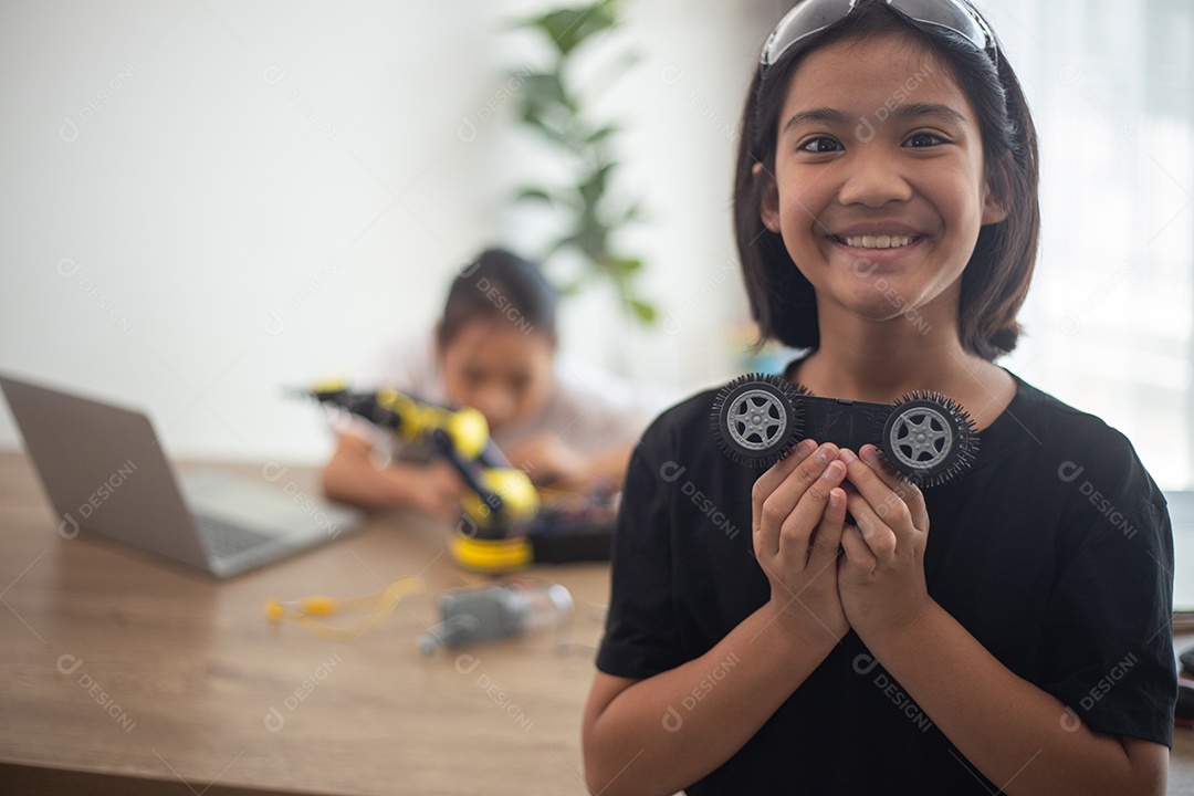 Crianças criativas aprendem em casa codificando carros-robôs e cabos de placas eletrônicas em STEM.