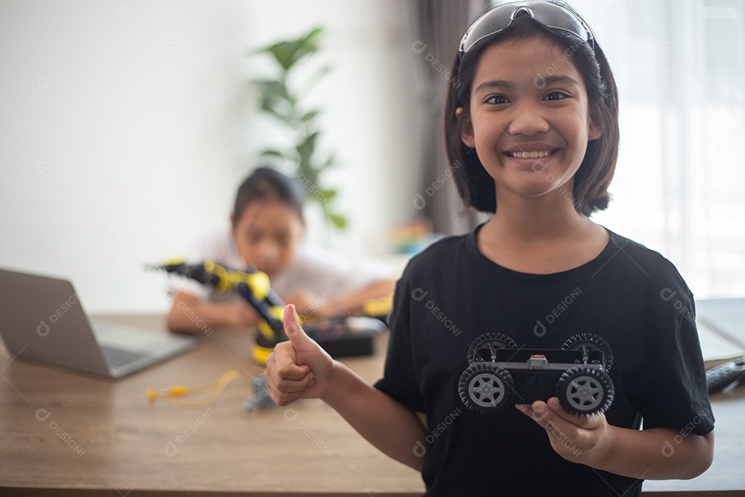 Crianças criativas aprendem em casa codificando carros-robôs e cabos de placas eletrônicas em STEM.