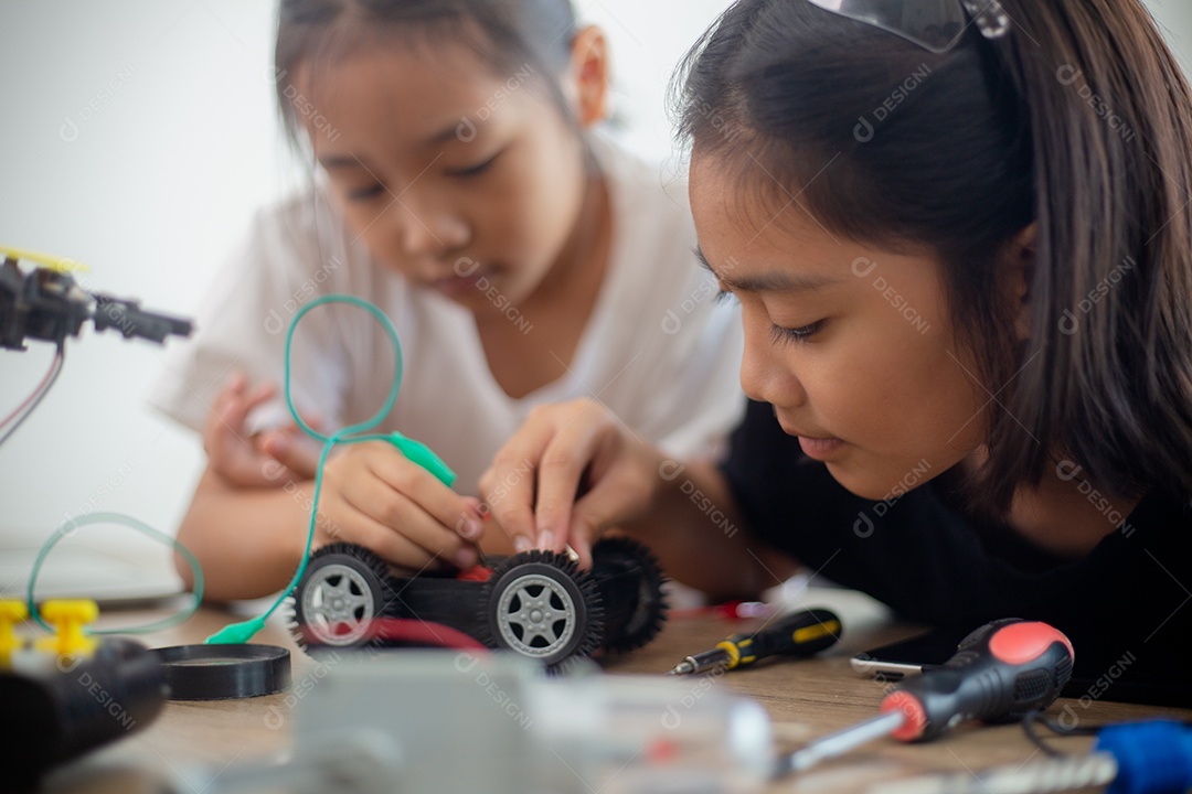 Crianças criativas aprendem em casa codificando carros-robôs e cabos de placas eletrônicas em STEM.