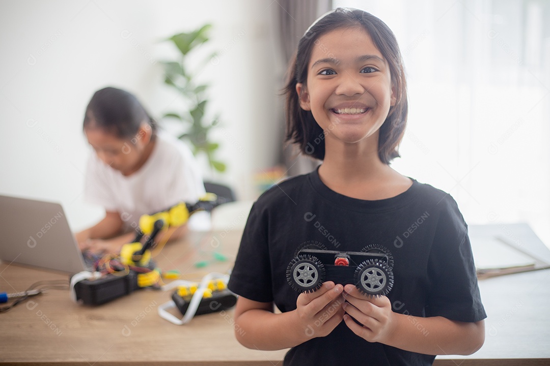 Crianças criativas aprendem em casa codificando carros-robôs e cabos de placas eletrônicas em STEM.