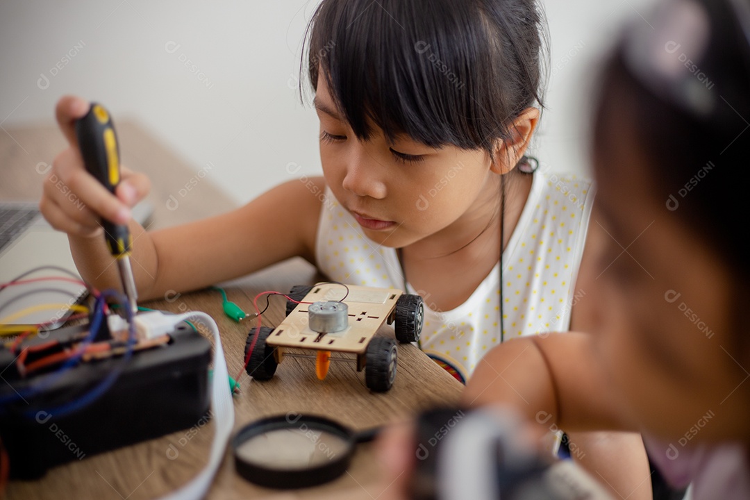 Crianças criativas aprendem em casa codificando carros-robôs e cabos de placas eletrônicas em STEM.